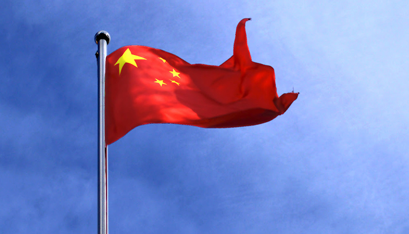 The flag of China against a blue sky.