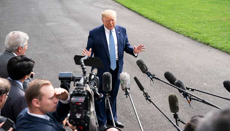 President Donald Trump talks to members of the press on the South Lawn of the White House. October, 2019.