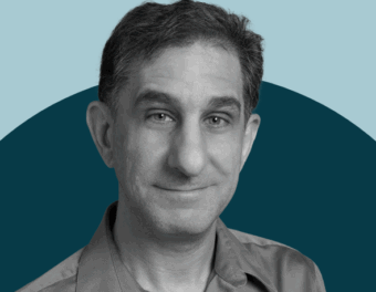 black and white headshot of David Hart on a two-tone blue background