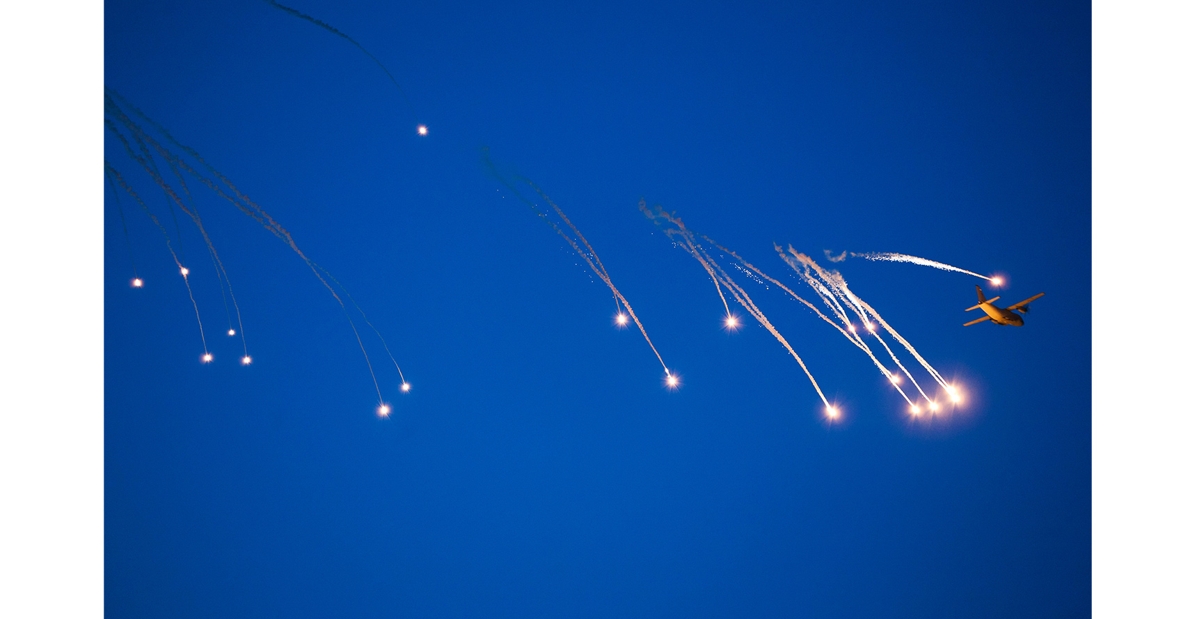 War plane dropping flares in evasion maneuver