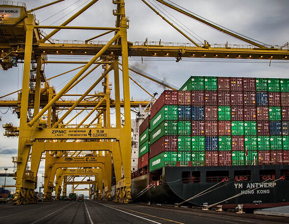 A Chinese container ship unloading stacks of shipping containers in port